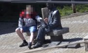 mężczyzna siedzi przy pomniku Rejewskiego i niszczy go wyłamując pióro