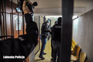 policjanci prowadzą zatrzymanego mężczyznę do aresztu