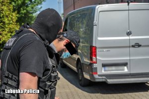 policjanci prowadzą zatrzymanego mężczyznę