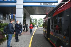 Zdjęcie kolorowe. Osoby stojące obok autobusu RCKiK&quot;&gt;