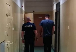 policjant prowadzi zatrzymanego