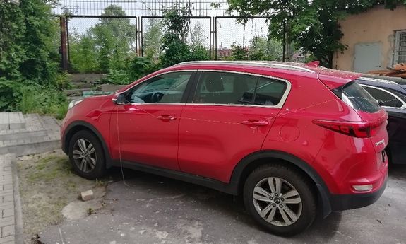 na zdjęciu widzimy czerwony samochód marki kia, który stoi na policyjnym parkingu