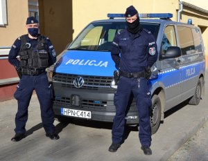 policjanci stojący przed radiowozem