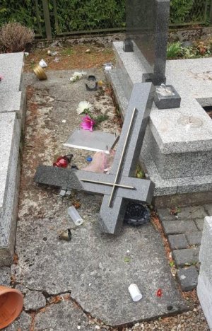 przewrócony krzyż na nagrobku