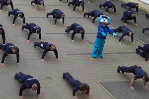 policjanci robią pompki na placu