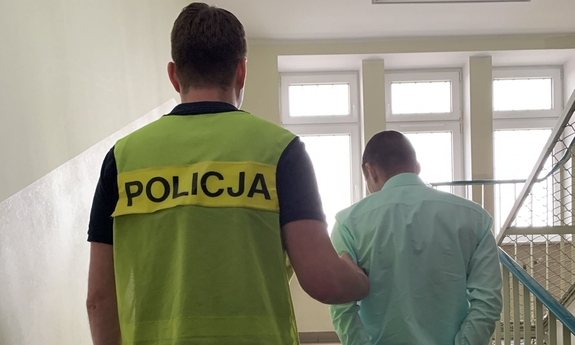 policjant prowadzi zatrzymanego mężczyznę