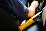 policjant za kierownica radiowozu, obok leży alcoblow