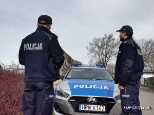 policjanci stoją przy radiowozie