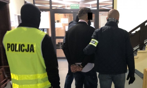 policjanci prowadzą zatrzymanego