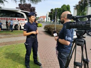 Media, które pojawiły się na miejscu oddawania krwi, oraz policjantka odpowiadająca na pytania dziennikarzy