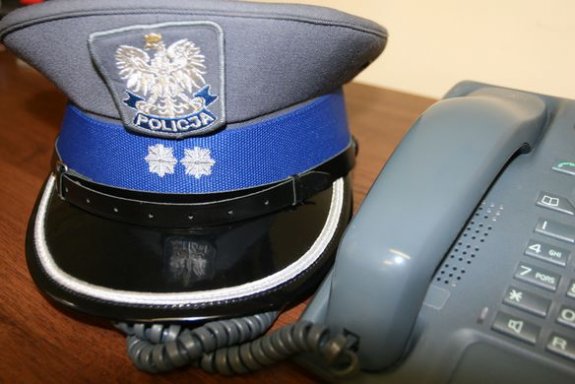 Czapka wyjściowa podkomisarza policji, leżąca obok aparatu telefonicznego