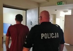 policjant prowadzi zatrzymanego
