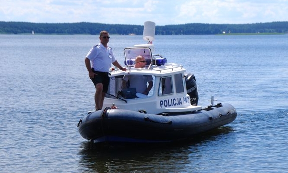 policjant na łodzi policyjnej na zbiorniku wodnym