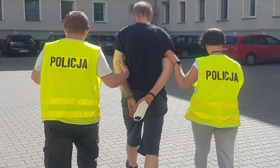 policjanci prowadzą zatrzymanego