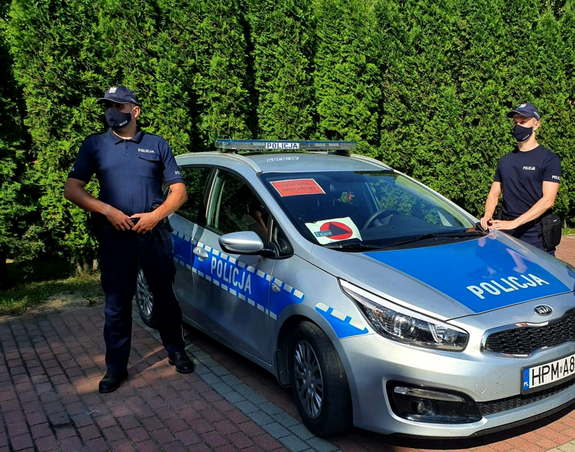 Dwóch policjantów  przy radiowozie