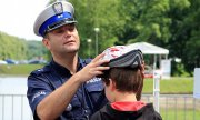 policjant zakłada kask rowerowy dziecku