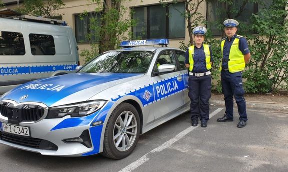 Policjantka z policjantem przy radiowozie