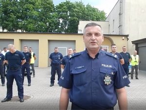 policjant w mundurze stoi na czele grupy policjantów