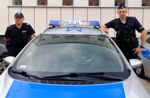 Policjanci którzy uratowali 38-latka stoją przy radiowozie