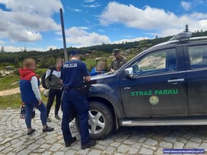 Policjant i strażnik rozmawiają z turystami