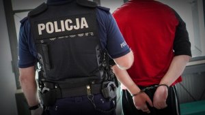 Policjant prowadzi zatrzymanego