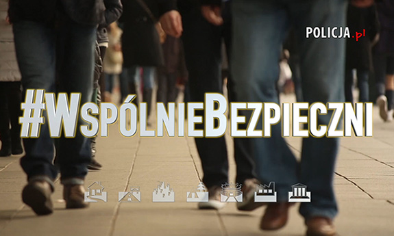 Na pierwszym planie napis #WspólnieBezpieczni, w tle idący ludzie