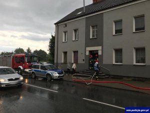 Kamienic w której był pożar, przed kamienicą stoi straż pożana i policja