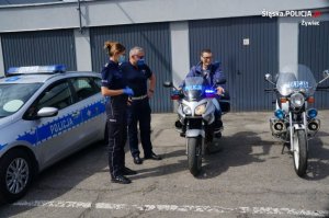 chłopak siedzi na motocyklu obok policjantka, policjant oraz drugi motocykl&quot;&gt;