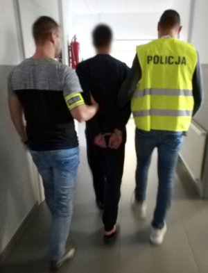 policjanci prowadzą zatrzymanego