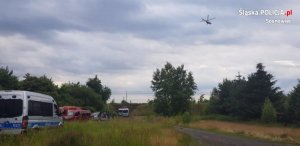 pojazdy użyte podczas poszukiwań oraz śmigłowiec latający nad terenem