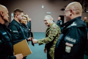 Policjanci stojący w rzędzie i żołnierz