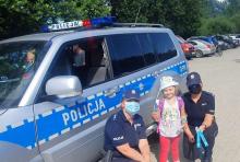 policjantka z dziećmi przy radiowzozie