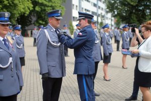 Komendant Szkoły insp. Jacek Gil wręcza medale za długolenią służbę.