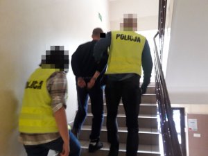 Policjanci prowadzą zatrzymanego