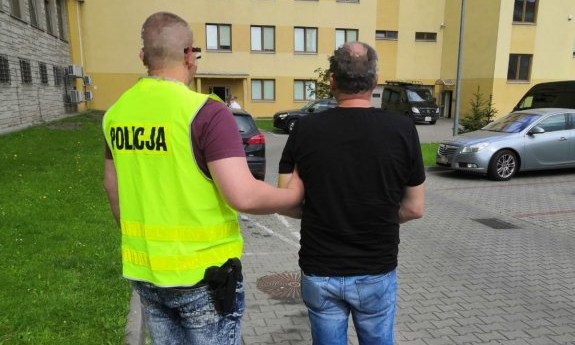 policjant prowadzi zatrzymanego mężczyznę