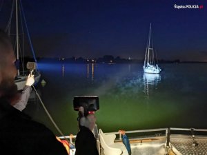 Częściowo widoczna łódź na zbiorniku wodnym w porze nocnej