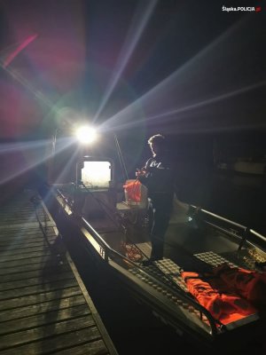 Częściowo widoczna łódź na zbiorniku wodnym w porze nocnej