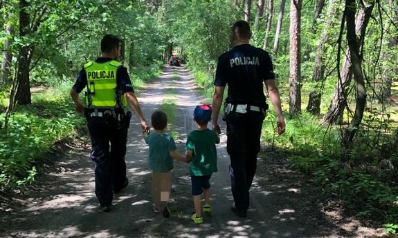 Policjanci prowadzą dwóch małych chłopców