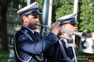 dwaj policjanci z orkiestry reprezentacyjnej policji, jeden z nich gra na trąbce