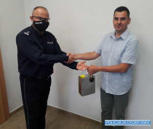 Komendant Policji w Złotoryi  wręcza podziękowania i upominek mężczyźnie