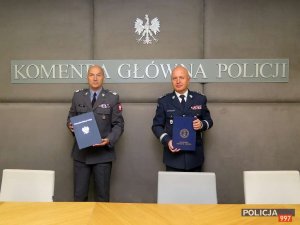 Komendant Główny Policji gen. insp. Jarosław Szymczyk i Dowódca Garnizonu Warszawa gen. dyw. Robert Głąb trzymają podpisane porozumienie o współpracy