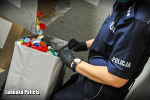 policjantka trzyma worek do którego wsypywane są nakrętki