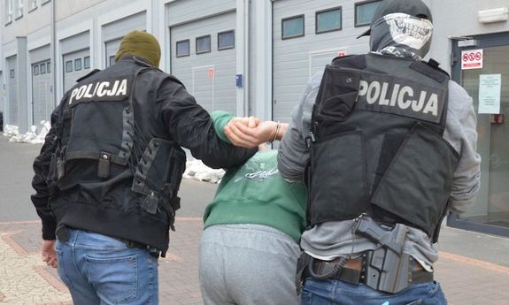 Policjanci prowdzą zatrzymanego