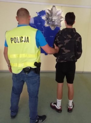 policjant prowadzi zatrzymanego