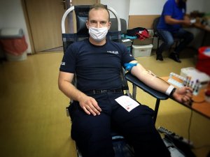 policjant na fotelu, w maseczce oddaje krew