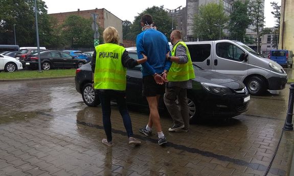 Policjanci prowadzą zatrzymanego