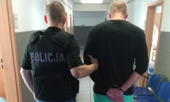 policjant prowadzi zatrzymanego mężczyznę