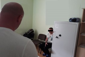 zatrzymany siedzi na krześle podczas przesłuchania