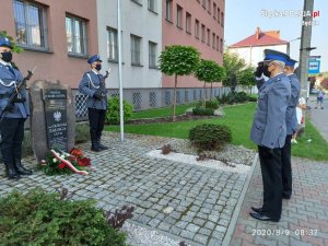 Policjanci oddający honory przed tablicą pamiątkową sierż. Grzegorza Załogi
