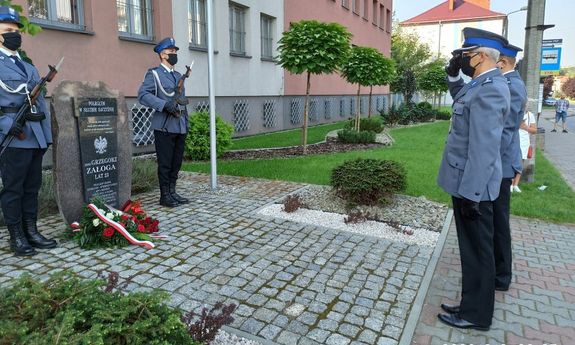 Policjanci oddający honory przed tablicą pamiątkową sierż. Grzegorza Załogi